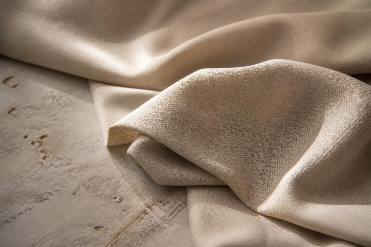 Close-up of a soft, draped fabric with a subtle sheen and visible woven texture